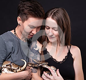 Photo of two happy women with snakes in hands