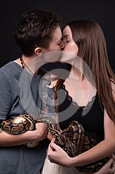 Photo of two kissing women with pythons