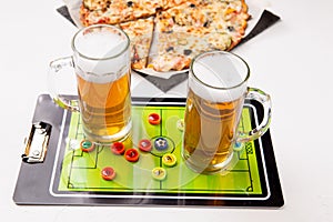 Photo of two mugs of beer, table football, pizza