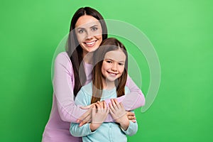 Photo of two people mother daughter smile cuddle empty space ad isolated on bright green color background