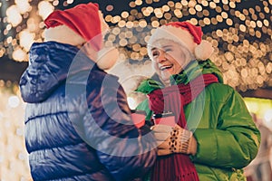 Photo of two people retired man woman meeting hold cup drink mulled-wine laugh x-mas joke comfort relax wear coat