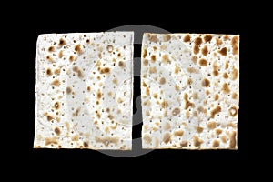 A photo of two pieces of matzah or matza isolated on black background. Matzah for the Jewish Passover holidays. Place for text, co