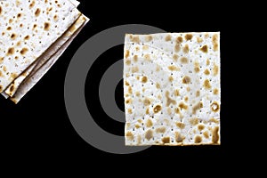 A photo of two pieces of matzah or matza isolated on black background. Matzah for the Jewish Passover holidays. Place for text, co