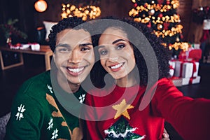 Photo of two positive funny people toothy smile take selfie record video christmas time decor lights indoors