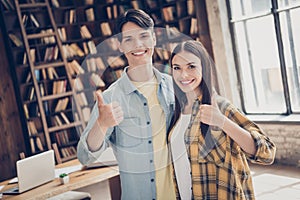 Photo of two smiling cheerful best friends woman and man college students showing thumb-up recommend university