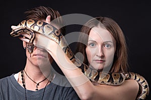 Photo of two women with python on closed eyes