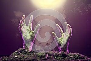Photo of two zombie hands sticking out of grave.