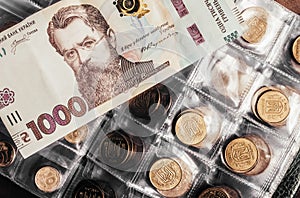 Photo of ukrainian banknote laying on coins holder