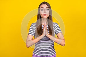 Photo of unhappy upset young woman hold hands together pray beg wish please isolated on yellow color background