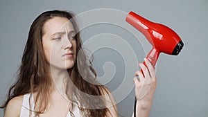 Photo of unhappy woman with damaged hair after hairdryer