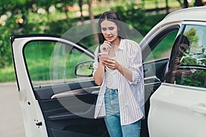 Photo of unsure minded girl driver ride car road lost check smartphone gps navigation hesitate bite lips teeth in town