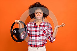 Photo of unsure uncertain young woman wear plaid shirt not knowing how control car isolated orange color background