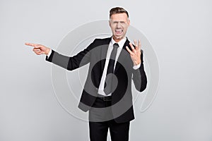 Photo of upset angry young leader wear black jacket shouting pointing finger empty space isolated grey color background
