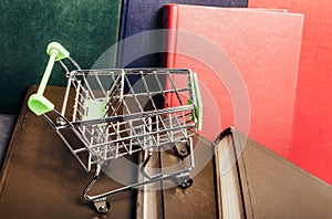 Photo of various colored books with shopping cart