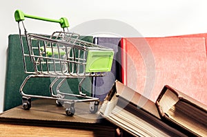 Photo of various colored books with shopping cart