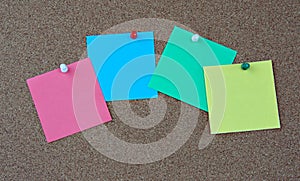 Photo of various colorful papers with space for text pinned with colorful pins on a note board