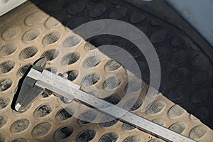 Photo of a vernier caliper with centimeters and millimeters. on a black background cutting mat