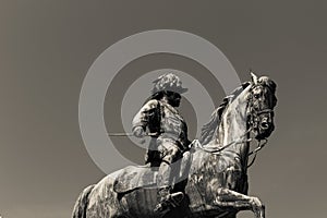 Photo of very high statue of a person on the horse in black and white colour