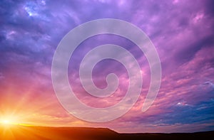 Photo of a violet sunset with clouds and sun