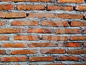 Photo of a wall made of red brick and a mixture of cement and sand which is usually used for building walls, houses and others