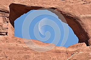 Wanning crescent moon caught in the middle of Skyline Arch photo