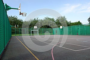 Multi-use sports court with basketball nets and football goals photo