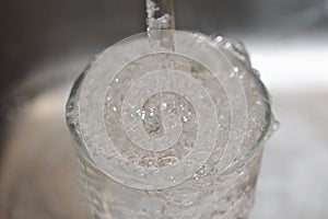 Photo of water pouring into an overfull glass