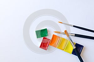 Photo of watercolor paints in cuvettes with brushes for water color painting