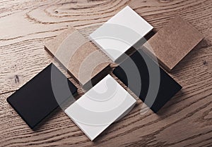Photo of white, black and craft business cards on wood table. Horizontal