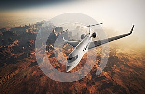 Photo White Glossy Luxury Generic Design Private Jet Flying in Sky under Earth Surface.Grand Canyon Background Sunrise