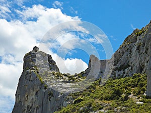 Wild landscape in the Alpilles in Provence in France with a rocky peak rising from a rocky terrain where scrubland abounds photo