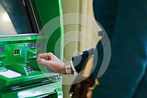 Photo of woman in coat at green cash machine