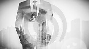 Photo of woman eye and businessman in suit. Double exposure skyscraper on the background. Black White