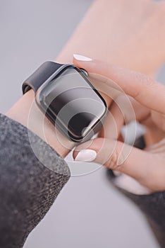 Photo of woman hands touching setting of smart watch, close-up