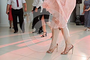 photo of woman legs in stylish high hell shoes on floor dancing at a wedding party