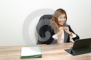 photo of woman in office with her hands in victory sign and smiling