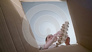 Photo of woman throwing carton container, bottom view