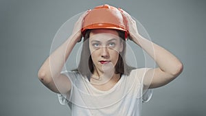 Photo of woman wearing orange helmet on grey
