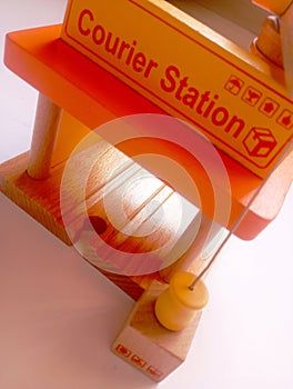 A photo of a wooden block shaped like a courier station styled in isolation with space for text photo