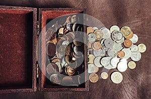 Photo of a wooden box filled with coins