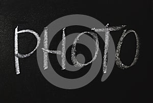 Photo word written in white chalk on a black chalkboard