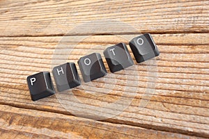 PHOTO wrote with keyboard keys on wooden background