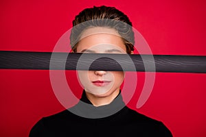 Photo of younf serious woman cover eyes tape justice blind adhesive isolated on red color background