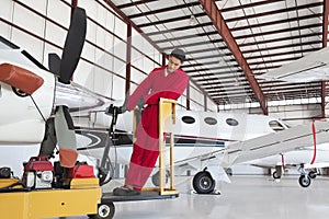 Portrait of young aeronautic engineer standing in front of an airplane propeller photo