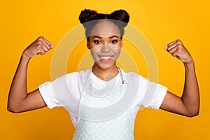 Photo of young african girl show arms muscle stength ready to clean the house isolated over yellow color background