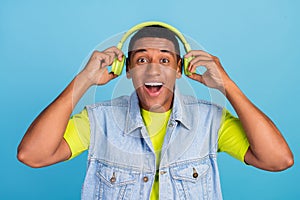 Photo of young afro guy have fun listen music earphones radio melody isolated over blue color background