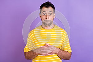 Photo of young amazed man shocked surprised face reaction stupor hold hands isolated over violet color background