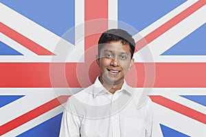 Portrait of young Asian man in shirt smiling against British flag