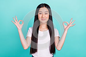 Photo of young attractive asian girl happy positive smile show okay alright choose sign isolated over turquoise color