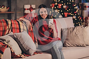 Photo of young attractive beautiful smiling good mood positive cheerful woman sit sofa typing sms on smartphone at home